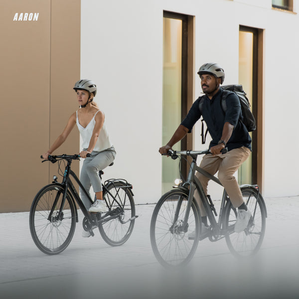 Zwei Radfahrer mit AARON Fit Fahrradgriffe - Ergonomisch - Schwarz fahren sicher und komfortabel in urbaner Umgebung.