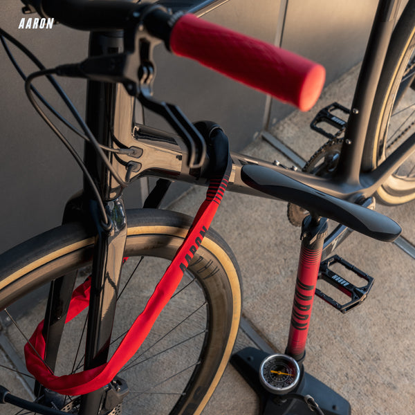 AARON Sport One Fahrradpumpe - Rot mit großem Manometer und stabilem Standfuß neben Fahrrad mit rotem Lenkergriff