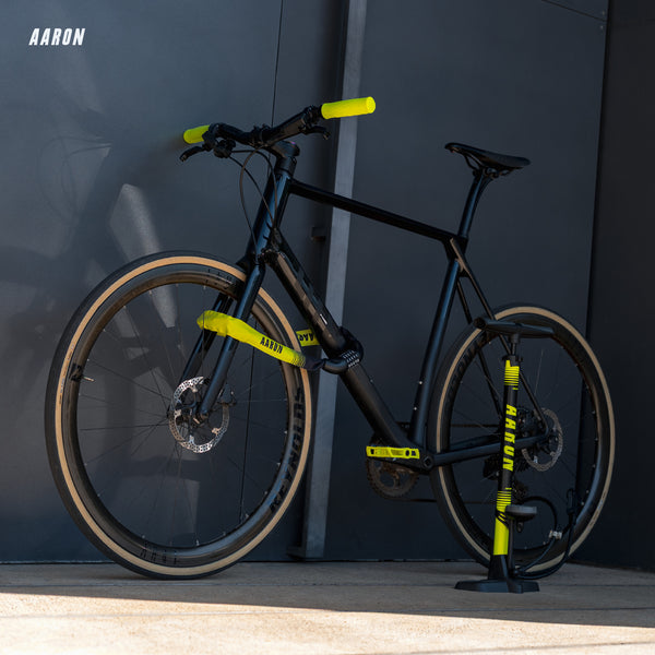 AARON Lock One Fahrradschloss mit Zahlencode Gelb gesichert an schwarzem Fahrrad vor dunkler Wand