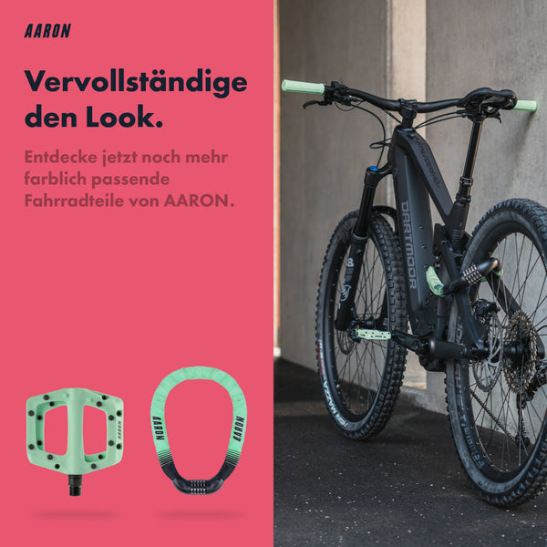 AARON Peak - MTB, Enduro & BMX Fahrradgriffe Mint am schwarzen Mountainbike mit Pedalen und Schloss in Mint.