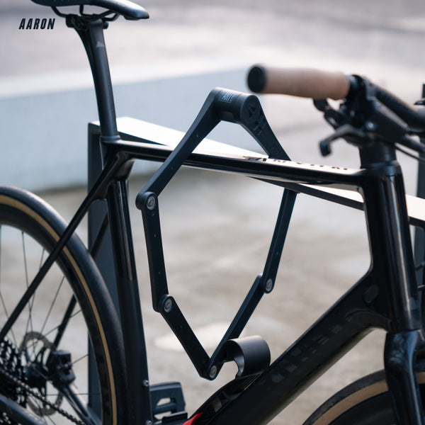 AARON Premium Pro Faltschloss 110 cm am schwarzen Fahrradrahmen befestigt, Sicherheitsstufe 18 für E-Bikes.
