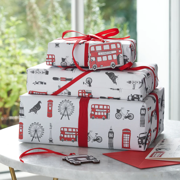 Gift Wrapping von AARON mit rotem Band und London-Motiven schützt Geschenke sicher während des Versands.
